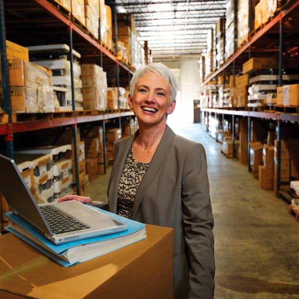 Person with computer in warehouse